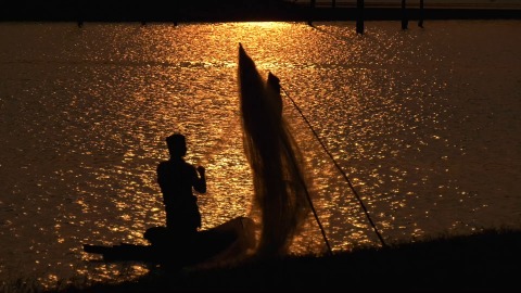 Fisherman along with his boat during sunset