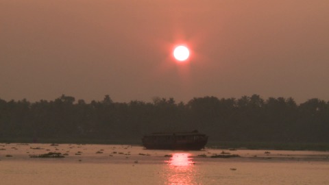 Houseboat cruising through Kumarakom during golden hour