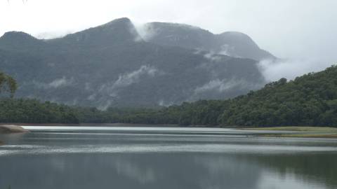 Lake surrounded by trees and hillocks in Kerala