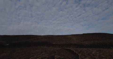 Cloudy sky above a rough terrain