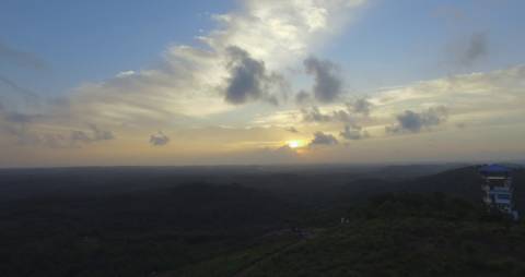 Sun hiding behind the clouds from hilltop