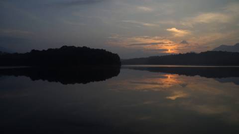 Sunset and silhouettes reflection on water