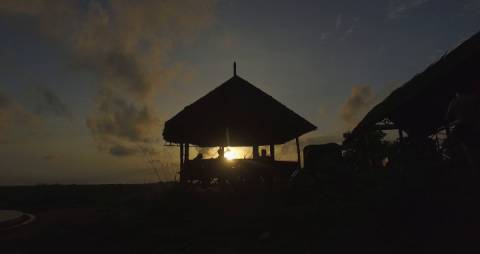 Silhouette of a hill top hut during sunset